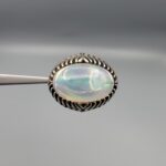 Studio close-up photographs showing the top and detailed side shank views of a 10+ carat natural Ethiopian opal ring crafted in solid sterling silver with an intricate Turkish design.