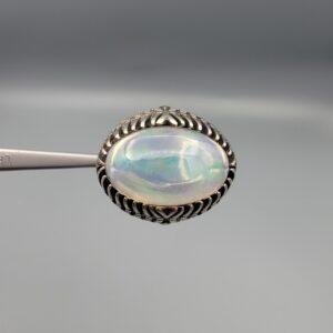 Studio close-up photographs showing the top and detailed side shank views of a 10+ carat natural Ethiopian opal ring crafted in solid sterling silver with an intricate Turkish design.