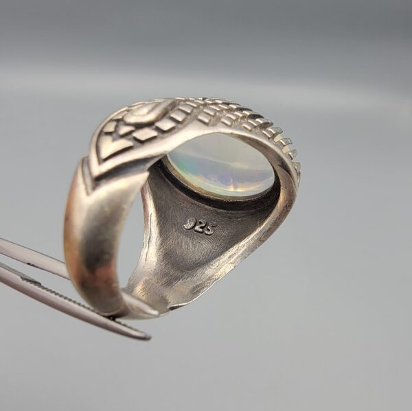 Studio close-up photographs showing the top and detailed side shank views of a 10+ carat natural Ethiopian opal ring crafted in solid sterling silver with an intricate Turkish design.