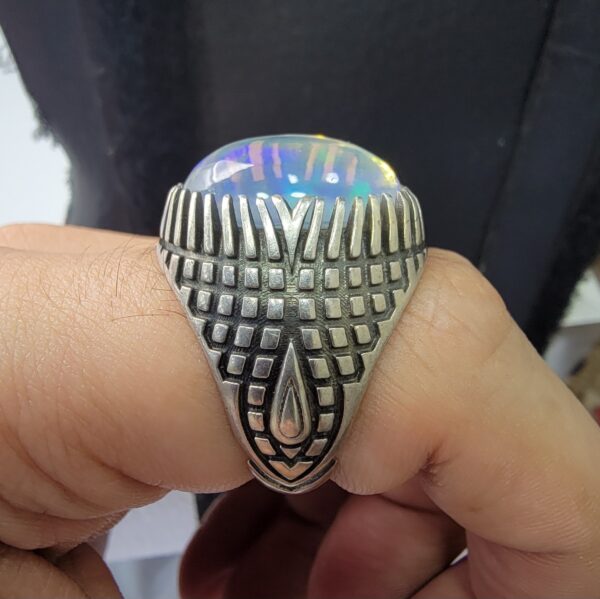 Studio close-up photographs showing the top and detailed side shank views of a 10+ carat natural Ethiopian opal ring crafted in solid sterling silver with an intricate Turkish design.