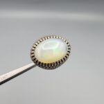 Studio close-up photographs showing the top and detailed side shank views of a 10+ carat natural Ethiopian opal ring crafted in solid sterling silver with an intricate Turkish design.