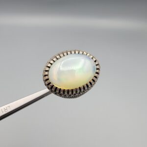 Studio close-up photographs showing the top and detailed side shank views of a 10+ carat natural Ethiopian opal ring crafted in solid sterling silver with an intricate Turkish design.