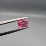Studio close-up photographs showing the top and facet profile views of a 0.63 carat cushion mixed cut natural rubellite tourmaline loose gemstone held in tweezers.