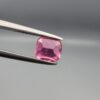 Studio close-up photographs showing the top and facet profile views of a 0.68 carat cushion mixed cut natural rubellite tourmaline loose gemstone held in precision tweezers.