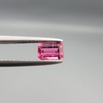 Studio close-up photographs showing the top and facet profile views of a 0.52 carat octagon cut natural rubellite tourmaline loose gemstone held in precision tweezers.