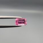 Studio close-up photographs showing the top and facet profile views of a 0.75 carat octagon cut natural rubellite tourmaline loose gemstone held in precision tweezers.