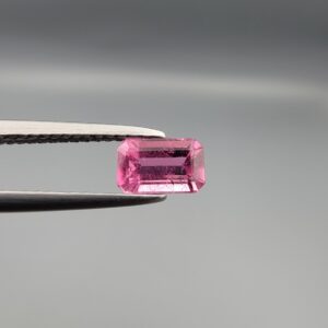 Studio close-up photographs showing the top and facet profile views of a 0.75 carat octagon cut natural rubellite tourmaline loose gemstone held in precision tweezers.