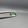 Studio close-up photographs showing the top and facet profile views of a 0.94 carat octagon cut natural blue tourmaline loose gemstone held in precision tweezers.