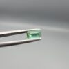 Studio close-up photographs showing the top and facet profile views of a 0.94 carat octagon cut natural blue tourmaline loose gemstone held in precision tweezers.