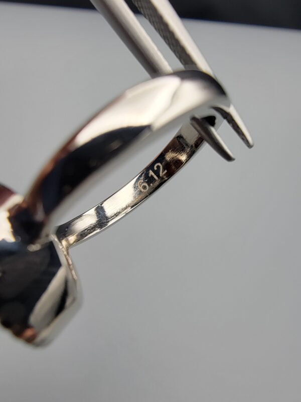 Studio close-up photographs showing the top oval face, 925 stamp, 6.12 weight hallmark, and side profile settings of a natural hessonite gomed sterling silver ring.