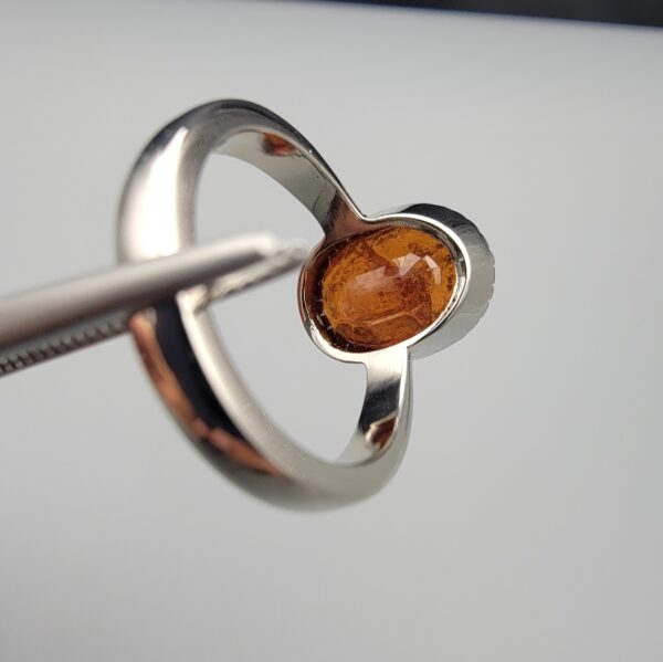 Studio close-up photographs showing the top oval face, 925 stamp, 6.12 weight hallmark, and side profile settings of a natural hessonite gomed sterling silver ring.