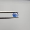 Studio close-up photographs showing the top table and side facet profile views of a 1.19 carat oval cut natural blue sapphire loose gemstone held in precision tweezers.