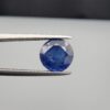 Studio close-up photographs showing the top table face and reverse natural mountain formation features of a 3.17 carat round cut natural blue sapphire loose gemstone held in precision tweezers.