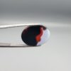 Studio close-up photographs showing the high-domed top surface, side profile, and reverse pattern views of a 17.43 carat oval cabochon natural multi-color agate loose gemstone held in precision tweezers.
