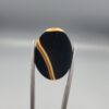 Studio close-up photographs showing the high-domed top surface, distinct natural "7" number pattern banding, and profile thickness views of a 21.69 carat oval cabochon Sulemani Aqeeq loose gemstone held in precision tweezers.