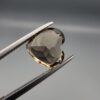 Studio close-up photograph showing the precision facet pattern, premium clarity, and rich brown color of a 3.33 carat heart shape brilliant cut natural smoky quartz loose gemstone held securely in tweezers.