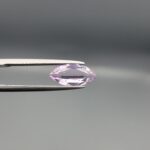 Studio close-up photographs displaying a 1.68-carat marquise-cut natural amethyst Katela gemstone held securely in precision tweezers against a neutral grey background.