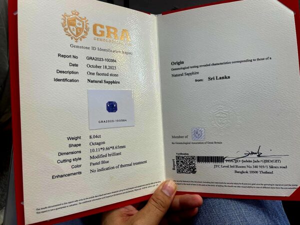 Official GRA Gemological Identification Report displaying the certification details and a photograph of an 8.04 carat, octagon-cut natural unheated pastel blue sapphire gemstone from Sri Lanka.