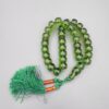 Studio close-up photograph of a 98-gram olive-green German Bakelite Sandaloos tasbih rosary, featuring barrel-cut polished beads, an intricately sculpted imam bead, and a rich green tassel against a light background.