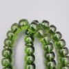 Studio close-up photograph of a 98-gram olive-green German Bakelite Sandaloos tasbih rosary, featuring barrel-cut polished beads, an intricately sculpted imam bead, and a rich green tassel against a light background.