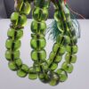 Studio close-up photograph of a 98-gram olive-green German Bakelite Sandaloos tasbih rosary, featuring barrel-cut polished beads, an intricately sculpted imam bead, and a rich green tassel against a light background.