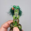 Studio close-up photograph of a 98-gram olive-green German Bakelite Sandaloos tasbih rosary, featuring barrel-cut polished beads, an intricately sculpted imam bead, and a rich green tassel against a light background.