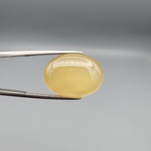 Multi-angle macro photographs of a 19.18-carat natural yellow chalcedony agate (Zard Aqeeq) oval cabochon from Iran held in metal tweezers, showcasing a smooth, domed surface, uniform honey-yellow translucency, and a high-gloss finish.