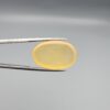 Multi-angle macro photographs of a 25.11-carat natural yellow chalcedony agate (Zard Aqeeq) oval cabochon held in metal tweezers, showcasing a smooth domed profile, uniform honey-yellow translucency, and a high-gloss reflective surface.