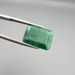 Multi-angle macro photographs of a 6.34-carat natural emerald (Panna / Zamrud) from the Swat Valley in Pakistan held in metal tweezers, showcasing an emerald cut, a vibrant green body, and characteristic internal crystal inclusions.
