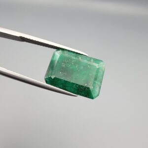 Multi-angle macro photographs of a 6.34-carat natural emerald (Panna / Zamrud) from the Swat Valley in Pakistan held in metal tweezers, showcasing an emerald cut, a vibrant green body, and characteristic internal crystal inclusions.