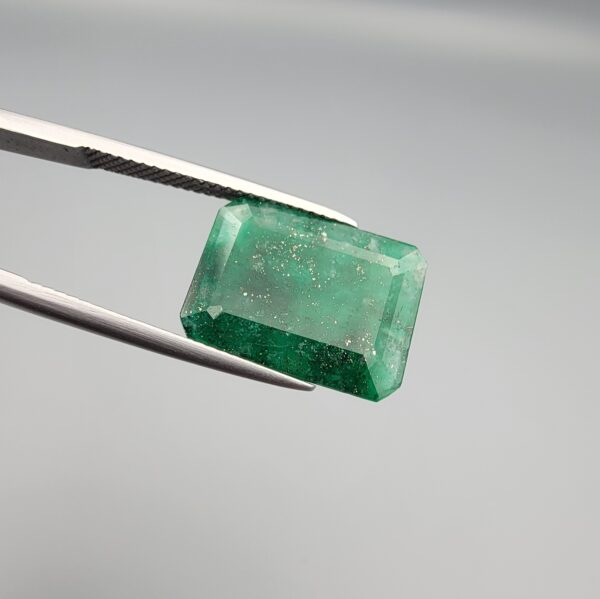 Multi-angle macro photographs of a 6.34-carat natural emerald (Panna / Zamrud) from the Swat Valley in Pakistan held in metal tweezers, showcasing an emerald cut, a vibrant green body, and characteristic internal crystal inclusions.