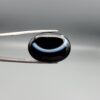 Exceptional 26.53 carat natural black banded agate (Sulemani Aqeeq), expertly finished into a high-gloss oval cabochon displaying a bold, curved concentric white band wrapping seamlessly around an intense jet-black core.