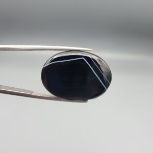 Striking 25.19 carat natural black banded agate (Sulemani Aqeeq) featuring a mirror-polished finish and clean, architecturally precise angular white banding lines contrasting against an intense jet-black body.