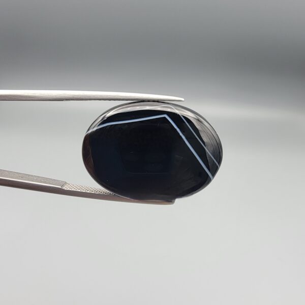 Striking 25.19 carat natural black banded agate (Sulemani Aqeeq) featuring a mirror-polished finish and clean, architecturally precise angular white banding lines contrasting against an intense jet-black body.