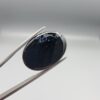 Rare 25.51 carat natural black banded agate (Sulemani Aqeeq) featuring a high-gloss finish and a captivating, crown-like cluster of orbicular cellular white eye formations along the top border of a jet-black cabochon.