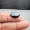 Rare 9.70 carat natural black banded agate (Sulemani Aqeeq), expertly finished into a high-gloss oval cabochon displaying a rich black rim encapsulating a translucent, luminous blue-grey crystalline matrix center.