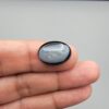 Rare 9.70 carat natural black banded agate (Sulemani Aqeeq), expertly finished into a high-gloss oval cabochon displaying a rich black rim encapsulating a translucent, luminous blue-grey crystalline matrix center.