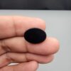 Rare 9.70 carat natural black banded agate (Sulemani Aqeeq), expertly finished into a high-gloss oval cabochon displaying a rich black rim encapsulating a translucent, luminous blue-grey crystalline matrix center.