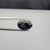 Multi-angle macro photographs of a 9.02-carat natural black banded agate (Sulemani Aqeeq) oval cabochon held in metal tweezers, showcasing a mirror-polished surface featuring an intricate, dense network of black and white crystalline dendritic and mosaic-like fracture patterns across the face.