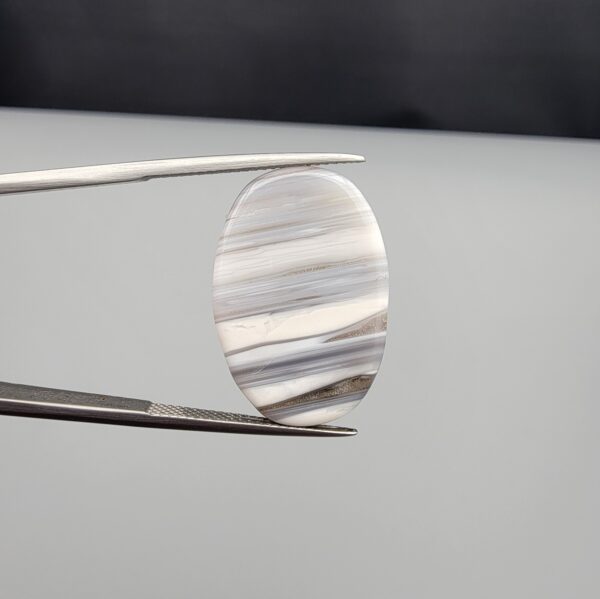 Exceptional 18.37 carat natural banded agate (Sulemani Aqeeq), expertly polished into an oval cabochon displaying delicate monochrome horizontal banding reminiscent of a serene wind-swept horizon.