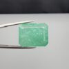 High-resolution digital scan of an official Galaxy Gemological Institute (GGI) Gemstone Report certificate (No. KHI2610700414) dated 14 October 2026 for a massive 19.56-carat semi-transparent green natural Emerald (Beryl) featuring an emerald step cut with moderate oiling.