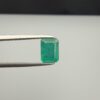 Multi-angle macro photographs of a 2.04-carat natural Zambian emerald (Zamrud) held in metal tweezers, displaying a classic emerald-cut octagonal shape, vibrant leafy green color, and characteristic natural internal inclusions (jardin) throughout the crystal structure.