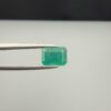 Multi-angle macro photographs of a 2.04-carat natural Zambian emerald (Zamrud) held in metal tweezers, displaying a classic emerald-cut octagonal shape, vibrant leafy green color, and characteristic natural internal inclusions (jardin) throughout the crystal structure.