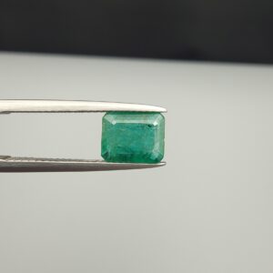 Multi-angle macro photographs of a 1.86-carat natural Zambian emerald (Zamrud) held in metal tweezers, showcasing a classic step-cut emerald octagonal shape, vibrant leafy green hue, and characteristic natural internal inclusions (jardin) across the table.