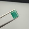 Multi-angle macro photographs of a 1.86-carat natural Zambian emerald (Zamrud) held in metal tweezers, showcasing a classic step-cut emerald octagonal shape, vibrant leafy green hue, and characteristic natural internal inclusions (jardin) across the table.
