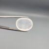 Macro photograph of a 15.30-carat natural Durr-e-Najaf (Clear Rock Crystal Quartz) cabochon held in metal gem tweezers against a neutral backdrop, displaying an oval polished cut, pure water-like transparency, and delicate natural internal veil inclusions.