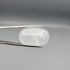 Multi-angle macro photographs showing a massive 41.67-carat natural Durr-e-Najaf (Clear Rock Crystal Quartz) cabochon held in metal tweezers and displayed on fingertips, showcasing an elongated smooth oval dome, water-clear transparency, and subtle organic internal veil growth.