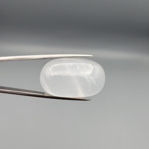 Multi-angle macro photographs showing a massive 41.67-carat natural Durr-e-Najaf (Clear Rock Crystal Quartz) cabochon held in metal tweezers and displayed on fingertips, showcasing an elongated smooth oval dome, water-clear transparency, and subtle organic internal veil growth.