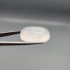 Multi-angle macro photographs showing a massive 41.67-carat natural Durr-e-Najaf (Clear Rock Crystal Quartz) cabochon held in metal tweezers and displayed on fingertips, showcasing an elongated smooth oval dome, water-clear transparency, and subtle organic internal veil growth.