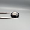 Multi-angle macro photographs of a 13.29-carat natural African Banded Eye Agate (Sulemani Aqeeq) held in gem tweezers, displaying a high round cabochon dome with concentric white and grey ringing around a translucent light core, a black border, and a reverse side showing undulating blue-grey wave banding.